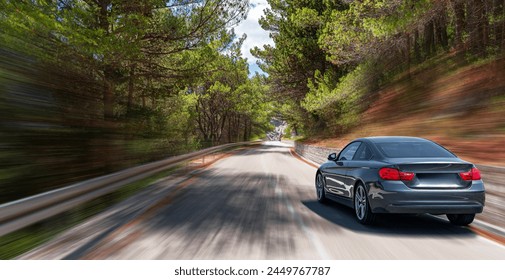 Une voiture roule à toute allure sur une route forestière. Effet de mouvement ajouté.