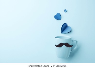 Charming father's day celebration concept. Top view of mustache mug and blue paper hearts on a light blue background with space for text