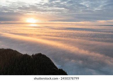O céu está cheio de nuvens e o sol está se pondo. As nuvens são brancas e fofas, e o sol está laranja e baixo no céu. A cena é pacífica e serena