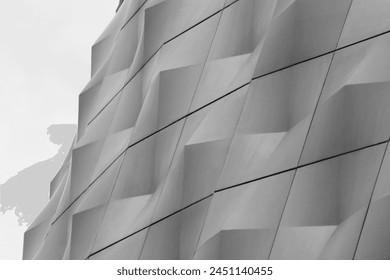 Panele metalike të strukturës së murit poliedrik. Sfondi abstrakt i arkitekturës moderne. Struktura gjeometrike e shumëkëndëshave. Model shumëkëndor i parregullt. Foto nga afër e ndërtesës së teknologjisë së lartë në stilin minimalizëm.