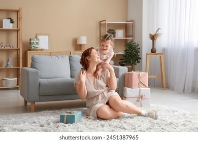 Cô bé ôm mẹ và chào mẹ bằng hộp quà tại nhà. Ngày của Mẹ