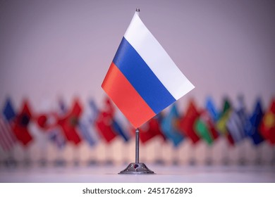 Bendera Rusia kecil berkibar di antara deretan bendera lain di bawah langit biru elektrik