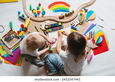 Fëmijë duke vizatuar dhe duke bërë punime artizanale në kopsht ose në çerdhe. Fëmijë të vegjël me lodra edukative dhe pajisje për aktivitete krijuese. Edukimi dhe zhvillimi i fëmijëve në parashkollor ose në çerdhe.