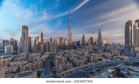 Dubai Downtown skyline with Burj Khalifa and other towers with long shadows during sunrise panoramic view from the top in Dubai, United Arab Emirates. Traffic on circle road and old style buildings