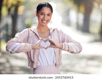 Ragazza, ritratto e attività all'aperto per il fitness, cuore e abbigliamento sportivo nella natura, sorriso ed esercizio su strada. Benessere, città e corsa con felicità, mani e gesti d'amore, salute e bokeh al parco.