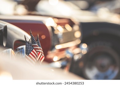 Small American flags on with a collection of classic American hot rods.