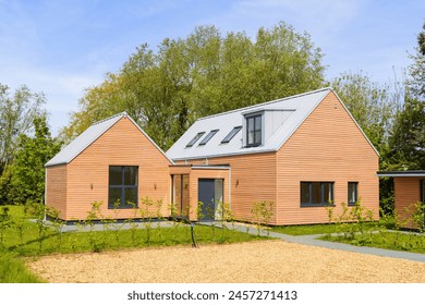 Detached modern wood larch clad new build home with a standing seam  metal clad roof in a rural setting. Suffolk. UK.