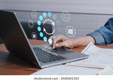 Working in office desktop Installing update system software for device operating systems to be up to date with the new version. Graphics icon showing updating function screen loading on laptop.