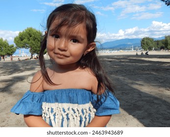 Cute little girl in summer suit (tropical poncho with fringes)