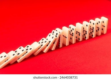 Effetto domino che agisce sui pezzi acrilici. Cadendo su uno sfondo rosso.