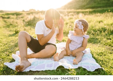 Anak-anak bermain di pegunungan pada hari musim panas. Anak-anak yang bahagia berpelukan dan duduk di atas selimut di rerumputan hijau di ladang saat matahari terbenam. Kakak laki-laki bermain dengan adik perempuannya di bawah sinar matahari musim semi. Menghabiskan waktu bersama.