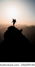 Alpinist pe vârful unui vârf de stâncă iluminat din spate la răsăritul soarelui în Pirinei