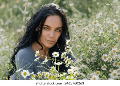 Linda mulher apreciando campo de margaridas de camomila. Linda mulher deitada em prado de flores de margaridas de verão. Linda garota em campo de grama de verão ao ar livre. Modelo morena e natureza verde de verão, conceito de harmonia.