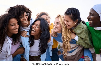 Grande grupo de jovens de diferentes raças, apenas mulheres amigas em pé, se divertindo nas costas ao ar livre. Mulheres multirraciais rindo e aproveitando o tempo de lazer juntas. Comunidade de garotas felizes da geração z