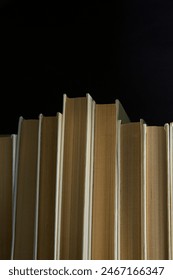Livros em fundo preto, instantâneo vertical, livros com capas brancas em fundo escuro