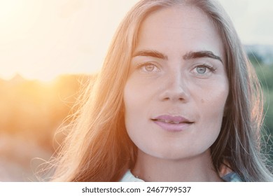 Amber Golden Hour Krupni plan žene okupane u zlatnočasovnom svjetlu koja pravi selfi na zalasku sunca u ljetnom parku. Sretni turist uživa u snimanju selfija na otvorenom za uspomene