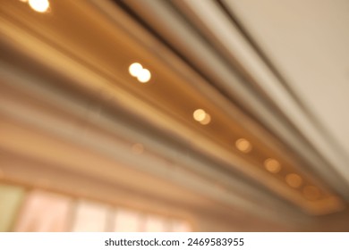 Desenfoque de enfoque del fondo de construcción de diseño de techo de luces interiores modernas. Lámpara LED de techo de sala de oficina interior en edificio de sala de arquitectura.