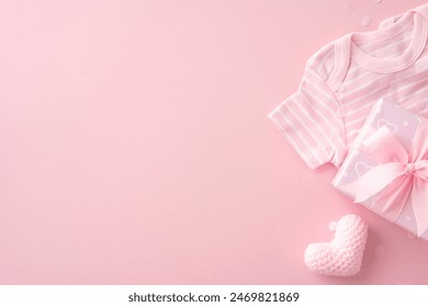 Susunan pancuran mandian bayi merah jambu lembut menampilkan onesie berjalur, hadiah berbalut dengan reben merah jambu dan mainan hati rajutan pada latar belakang merah jambu