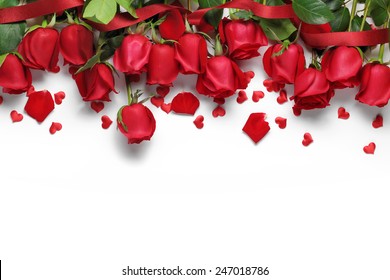 Rosas rojas y adornos en forma de corazón sobre fondo blanco.