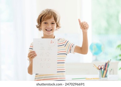 Dziecko trzymające szkolny test z doskonałą oceną A. Uczeń zadowolony po egzaminie. Mały chłopiec z papierem do notatek A w rękach. Korepetycje i pomoc w odrabianiu prac domowych dla uzyskania najlepszych ocen w szkole.