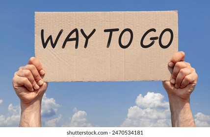 Ruce držící kus kartonu s nápisem "way to go"