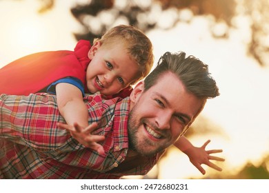 Lelaki, kanak-kanak dan piggyback untuk kapal terbang dalam potret untuk keseronokan, fantasi atau pembangunan di taman. Anak lelaki, bapa atau bermain di luar pada waktu petang untuk terbang, hiburan atau permainan di belakang rumah untuk ikatan