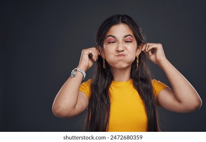 Komödie, Schielen und Mädchen im Studio für lustigen Witz mit Humor und verrückte Pose für alberne Emoji mit Mockup-Raum. Weiblicher Teenager, Comic-Meme und Ohren berühren mit Lächeln für Glück vor dunklem Hintergrund