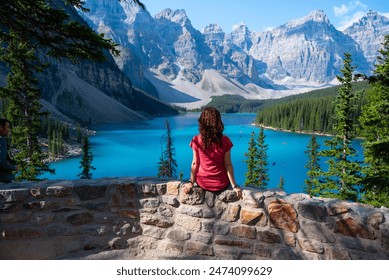 Turistkinja sjedi ispred jezera Moraine u Kanadi