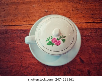 cốc trắng có hoa hồng đỏ trên đó