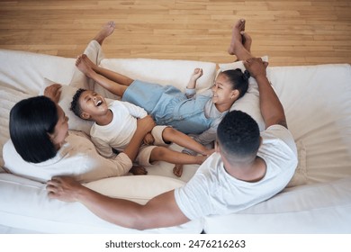 الحب والضحك والأطفال مع الوالدين على الأريكة مع منظر علوي ودغدغة ومرح وترابط في منزلهم معًا. الدعم والأمان والأسرة السعيدة في غرفة المعيشة للألعاب واللعب والكوميديا ​​والرعاية أو المزاح