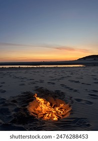 sunset beach bonfire: warm flames of a beach fire light up the evening as the sun sets over the ocean. enjoying the cozy atmosphere and the soothing sounds of waves.