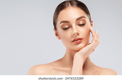 Beautiful young woman with clean fresh skin on face . Girl facial treatment . Cosmetology , beauty and spa .