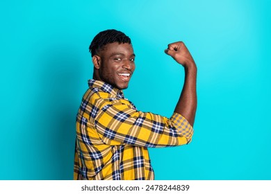 Photo of nice cheerful man wear trendy checkered clothes showing hand fist isolated on cyan color background