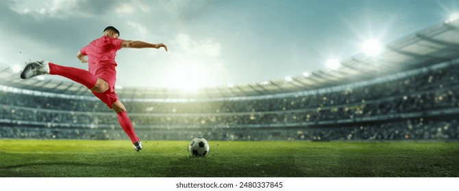 Afiş. Sinematik görünüm. Kırmızı giysili futbolcu, seyircilerle dolu aydınlık bir stadyumda topa güçlü bir şekilde vurarak kaleyi hedefliyor. Spor oyunları, yarışma, şampiyonluk, turnuva kavramı. Reklam