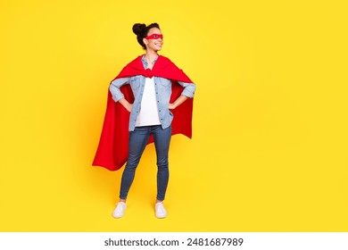 Volledig lichaamsportret van een mooi jong meisje dat eruitziet als een leeg superheldenkostuum geïsoleerd op een gele achtergrond