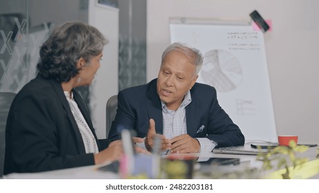 Bătrân bătrân indian supărat trist femeie șezând scaun argumentând dispută tratarea reclamațiilor clienților la biroul de locuri de muncă din interior. Bătrân supărat șeful bărbați femeie angajată care se luptă pentru serviciul de asigurare bancară prost