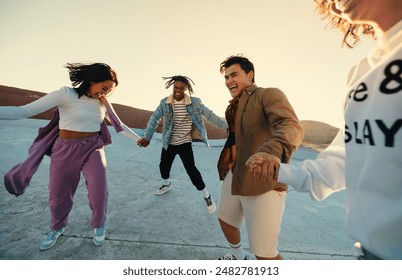 Group of friends dancing and enjoying a fun, spontaneous moment outdoors at sunset. Capturing their candid and happy expressions.