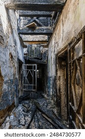 Corridor of burnt house, charred walls. Consequences of fire, war, etc..