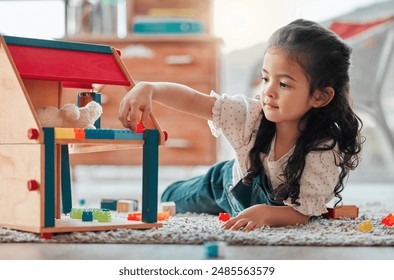 Girl, dollhouse and child play on floor, games and fantasy for brain development in home. Female person, toys and blocks on ground for entertainment, growth and toddler for education or learning