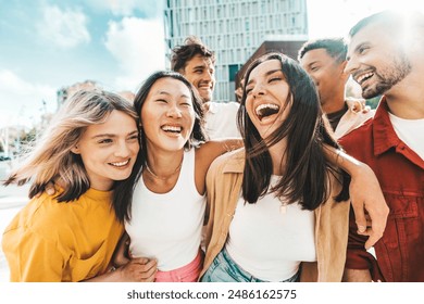Multiethnic friends having fun walking on city street - Group of young people enjoying summer vacation together - Friendship concept with guys and girls hanging outside on a sunny day