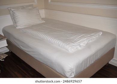 a picture of single bed in one of countries European hotel
