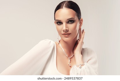 Beautiful young woman with clean fresh skin on face . Girl in white dress and silver jewelry , facial  treatment   . Cosmetology , beauty  and spa .