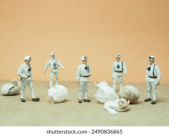 ぼやけた背景のテーブルに置かれたアクションフィギュアのミニおもちゃ。おもちゃの写真コンセプトデザイン。科学者のチームが謎の卵を発見。
