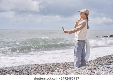 Una niña de cuatro patas se toma un selfie en la orilla del mar. El concepto de entretenimiento donde los niños se disfrazan de animales y lo combinan con ejercicios de gimnasia. Foto de alta calidad