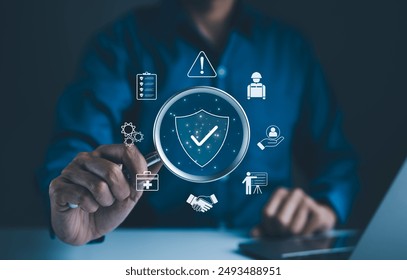 Work Safety and Compliance Concept. Businessman holding magnifying glass with icons work safety, compliance, risk management, and operational efficiency, emphasizing importance of safety standards.