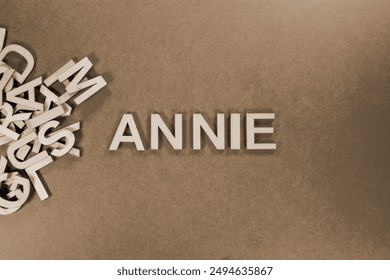 Populär a modern Puppelchen Meedchen Moudenumm ANNIE an hëlzent englesch Sprooch Kapital Buschtawen aus engem Koup Bréiwer op engem gréngen Hannergrond a Sepia spilling