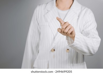 Businesswoman in white dress standing pointing finger, finger, touch