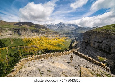 A woman who looks out over a viewpoint to see the impressive Ordesa valley in the Spanish Pyrenees.