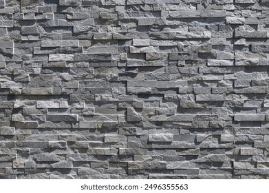 Rivestimento in pietra di muro fatto di mattoni accatastati a strisce di rocce grigie naturali. Rivestimento esterno, sfondo e texture.