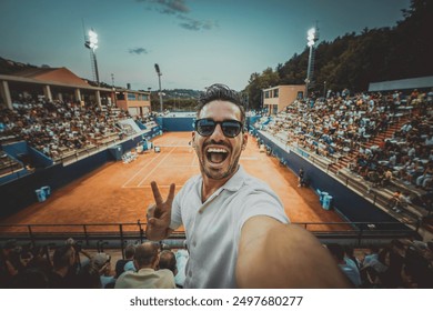Stadyumda grand slam turnuvası maçını izlerken selfie çeken yakışıklı genç tenis seyircisi - Spor ve teknoloji yaşam tarzı konsepti